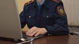 Полицейский сидит за ноутбуком