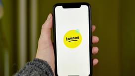 Мужчина держит смартфон с логотипом Lemon8