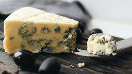 Сыр с плесенью и оливки на столе