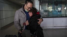 Мужчина и женщина обнимаются в аэропорту Пекина