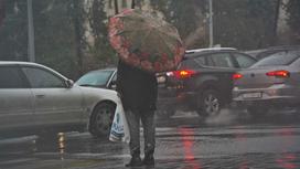 Женщина с зонтом переходит дорогу