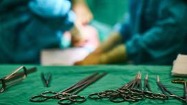 Хирургические инструменты лежат на зеленой скатерти
