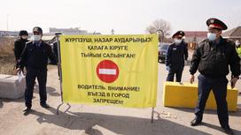 полицейские стоят на блокпосту на въезде в Алматы