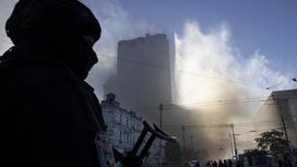 Сотрудник полиции рядом с пострадавшим от взрыва зданием в Киеве 17 октября