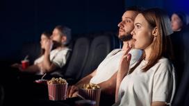 Пара смотрит фильм в кинотеатре