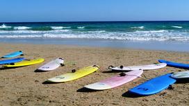 Доски для серфинга лежат на песке