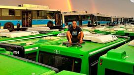 Аюп Бейбi на фоне автобусов