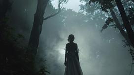 Девушка идет через лес в тумане