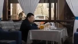 Мужчина сидит в кафе за столиком в Шымкенте