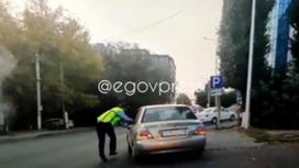 Полицейский рядом с машиной в Шымкенте