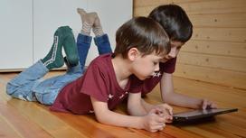 Два мальчика играют на планшете