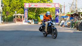 Мужчина в маске на мотоцикле в Индии
