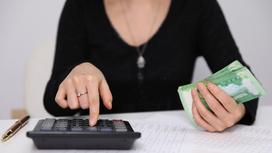 Женщина с калькулятором и деньгами