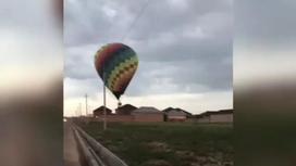 Воздушный шар летит на линии электропередач в Шымкенте