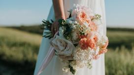 Невеста в свадебном платье с букетом в руке