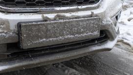 Автомобильный номерной знак покрыт грязьюи снегом