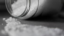 Крупная соль рассыпана по столу