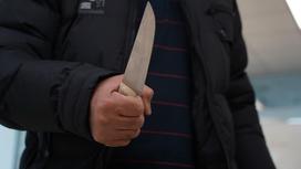 Мужчина держит нож в руке