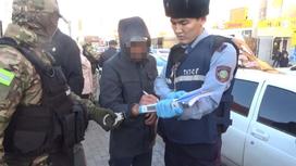 Полицейский рядом с задержанным в Караганде