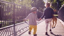 Двое детей идут по мосту