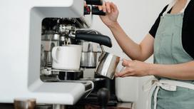 Работница кофейни наливает кофе