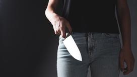 Женщина держит нож в руке