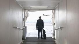 Мужчина с багажом смотрит на самолет