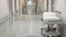 Передвижная больничная койка стоит в коридоре больницы