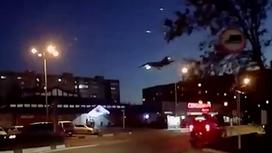 Падающий военный самолет над городом