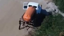 Мужчина сливает каловые массы из ассенизаторской машины