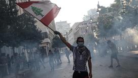 мужчина с флагом Ливана стоит на улице
