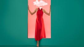Женщина в красном платье, у которой вместо головы облако, делает шаг