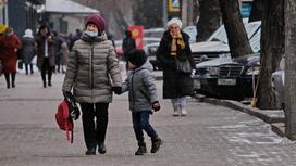 Женщина и ребенок идут в масках по улице
