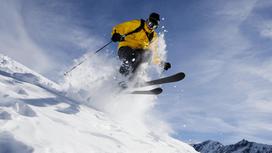 Лыжник прыгает во время спуска по склону горы