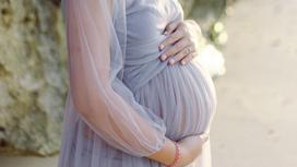 Беременная женщина в сиреневом платье