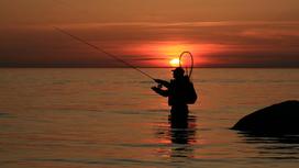 Мужчина рыбачит на закате