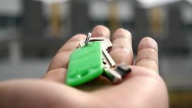 Ключи в руках на фоне домов