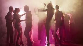 Люди танцуют в ночном клубе в дыму