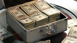 Кейс заполненный долларами и доллары на столе