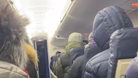 Люди в теплых куртках сидят в самолете