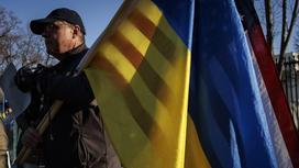 Мужчина с американским и украинским флагами