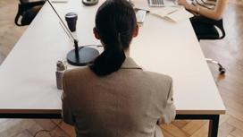 Женщина сидит за столом в офисе