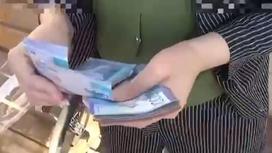 Девушка пересчитывает деньги в Кызылординской области