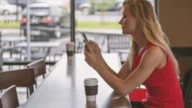 девушка сидит за столиком в кафе