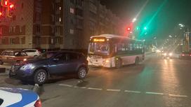 Автобус с вмятиной и автомобиль стоят посреди дороги