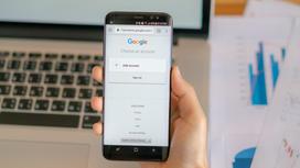 Человек держит телефон с логотипом Google
