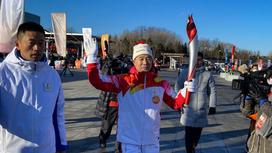 Китайский астронавт Цзин Хайпэн держит Олимпийский огонь