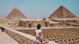 Девушка смотрит на пирамиды в Египте