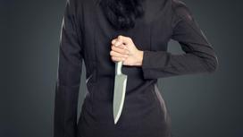 Женщина держит нож за спиной