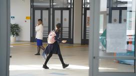 Школьница идет по коридору в школе